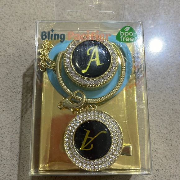 Other - Bling gold and blue letter A dummy and  Holder 
BPA approved
6-12m